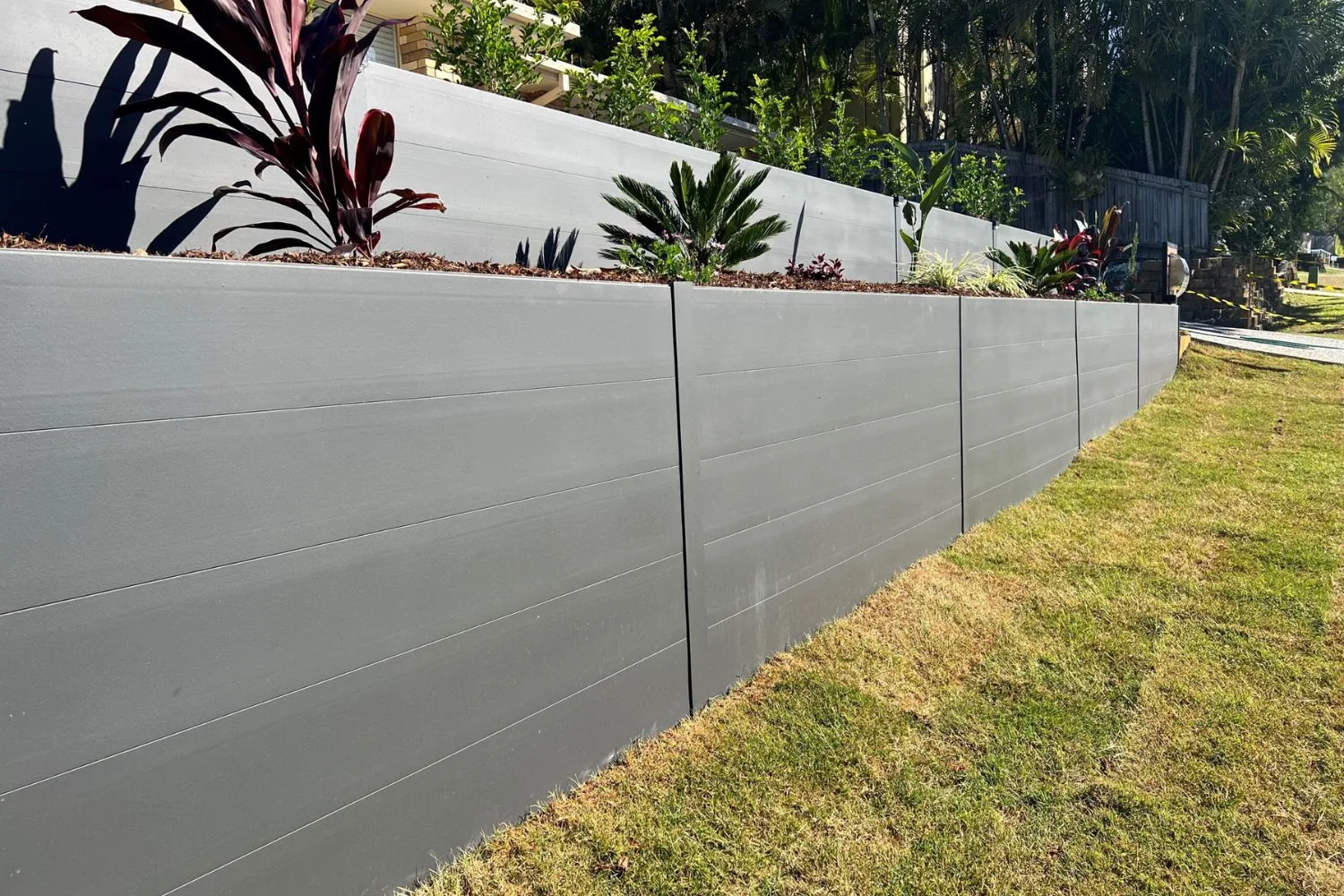 Finished grey concrete retaining wall on a commercial-scale site