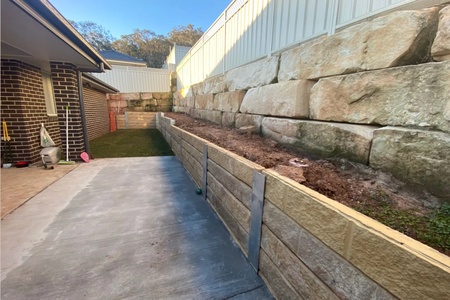 Concrete sleeper retaining wall along a garden bed