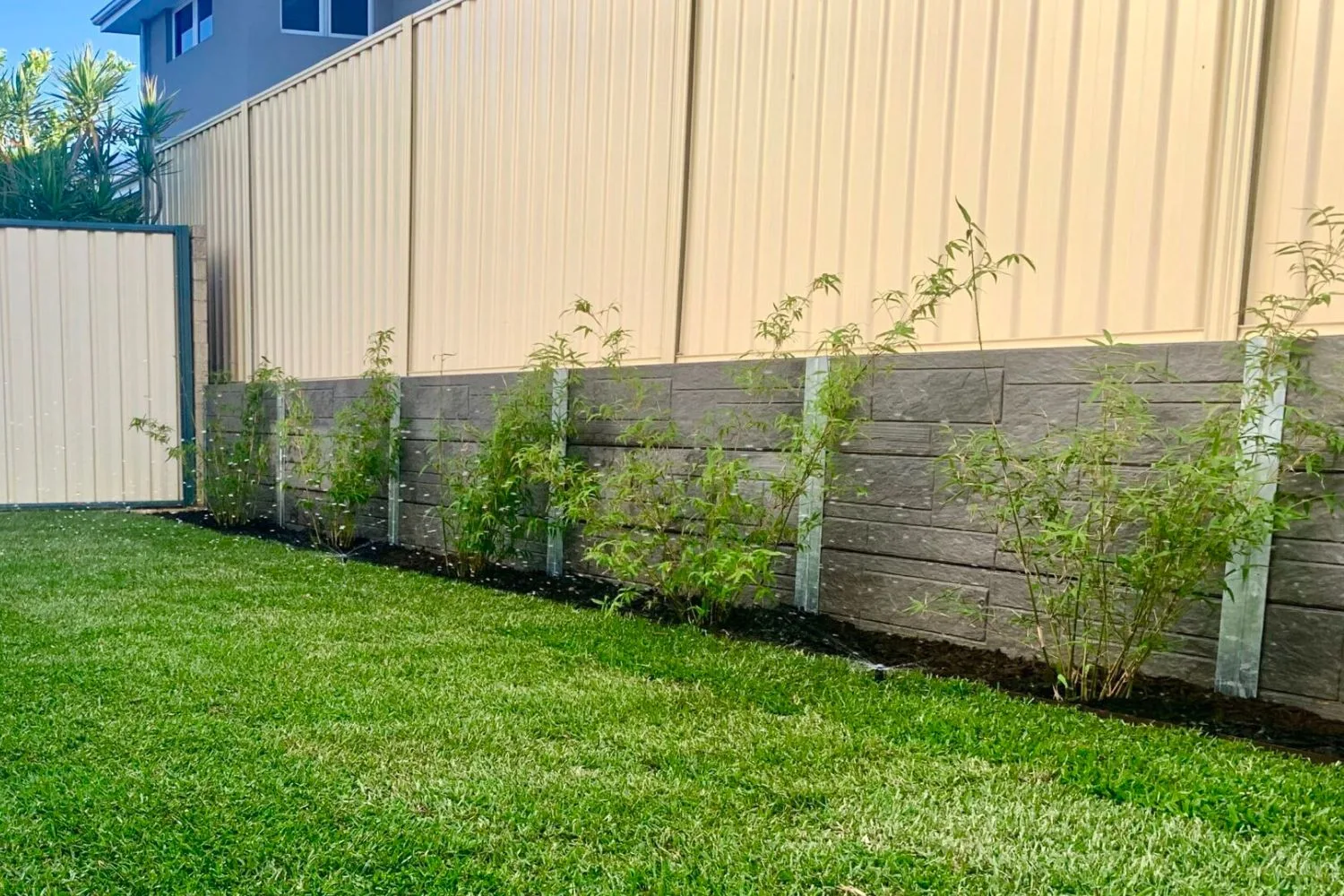 Concrete sleeper retaining wall along a driveway