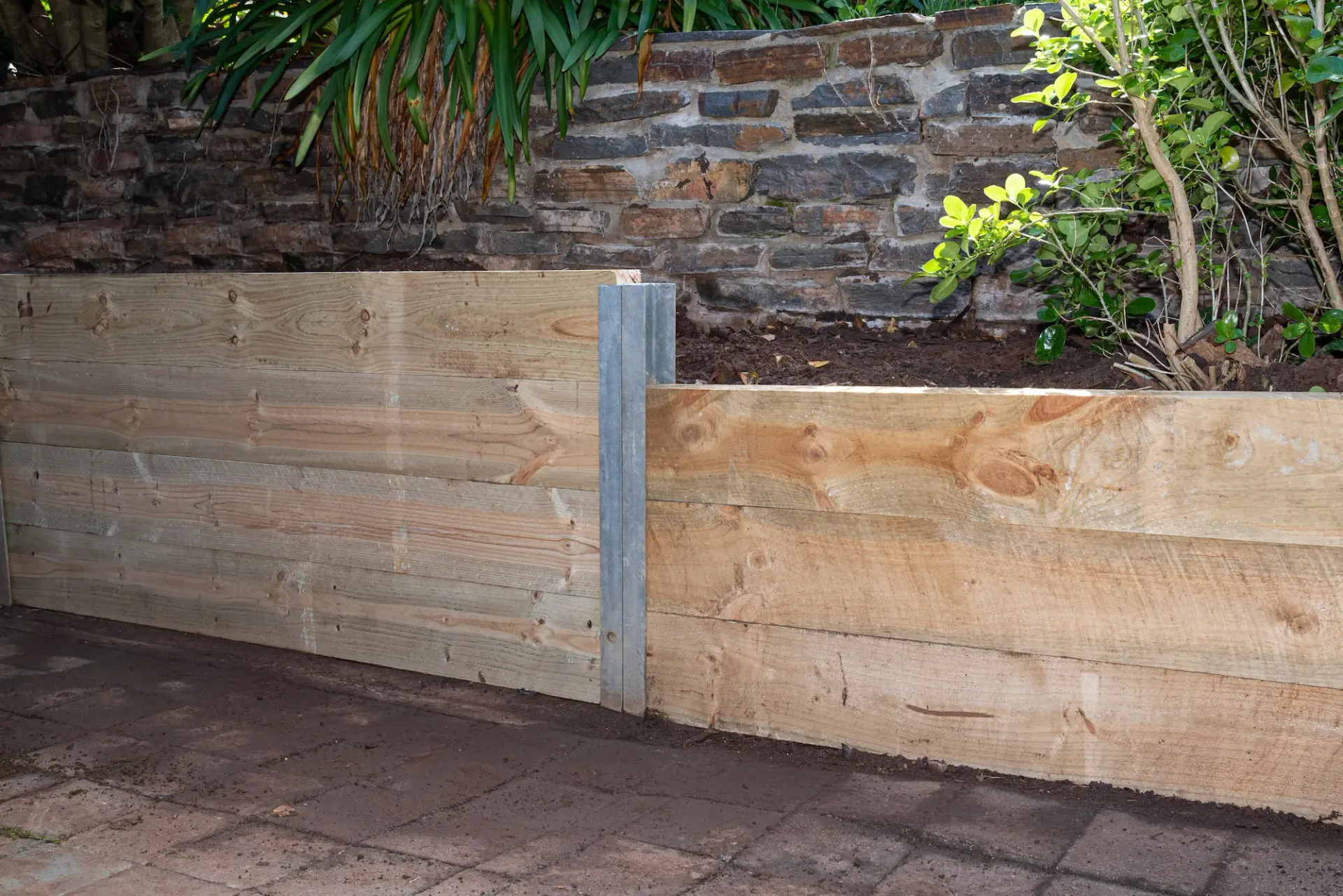 Timber retaining wall along a garden bed